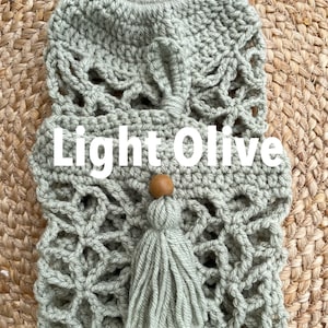 May include: Light olive green crocheted bag with a tassel and wooden bead. The bag has a delicate, intricate design.