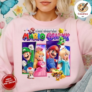May include: Pink sweatshirt featuring the text "THE SUPER MARIO GALAXY" with images of Mario, Luigi, Princess Peach, and other characters. The design includes a high-quality PNG image with 300 DPI.