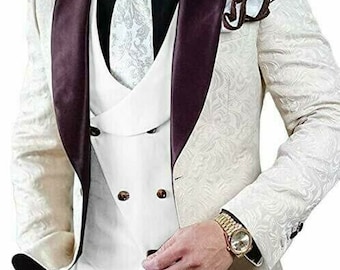 May include: A white patterned suit jacket with a burgundy satin lapel and a white vest. The suit jacket has a double-breasted closure and a white pocket square.