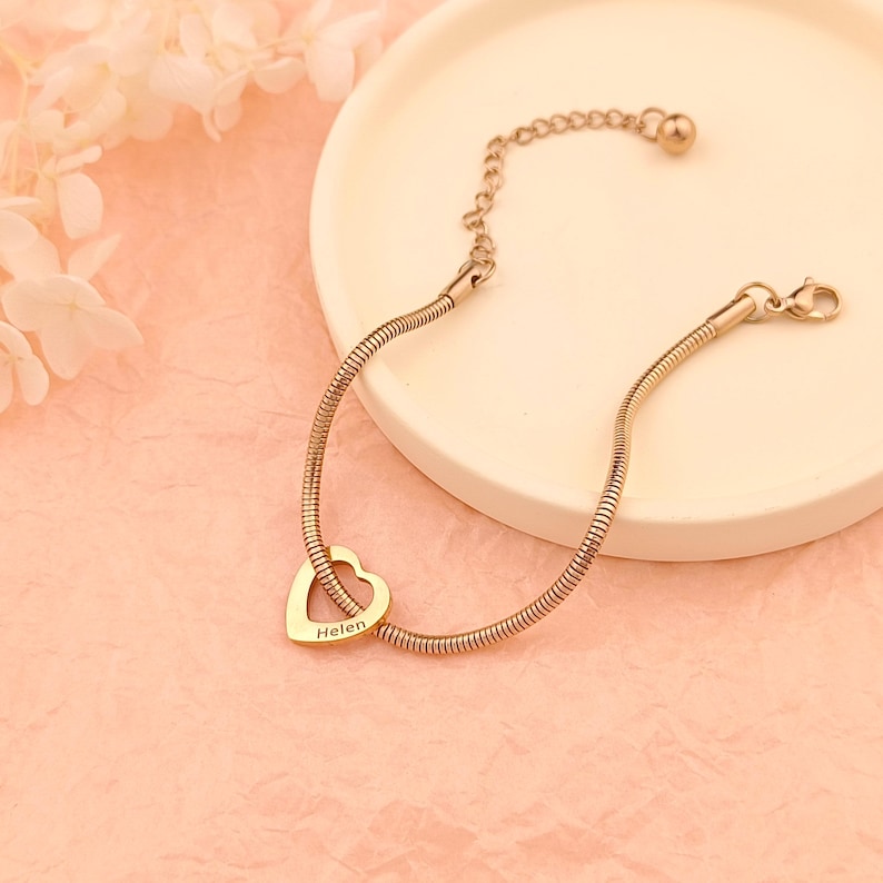 May include: A gold-toned snake chain bracelet with a heart-shaped charm that says "Helen" on it.