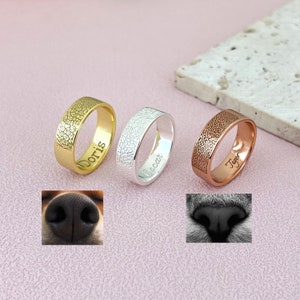 Puede incluir: Tres anillos de identificación para mascotas personalizados en oro, plata y oro rosa con los nombres grabados "Doris", "Oscar" y "Tiger".