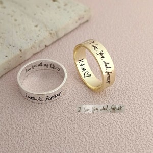 May include: Two silver and gold rings with handwritten messages engraved on them. The silver ring says "Love you all my life" and "Love & Forever". The gold ring says "I love you dad forever" and "B+K".