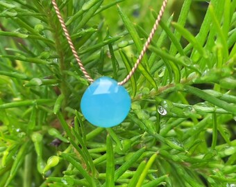 May include: A delicate necklace featuring a single, round, light blue gemstone pendant. The pendant hangs from a thin, gold chain.