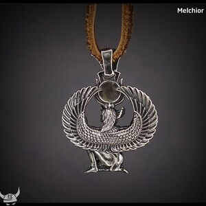 Puede incluir: Collar con colgante de plata que representa una representaci&oacute;n detallada de la diosa egipcia Isis con alas extendidas. El colgante est&aacute; unido a un cord&oacute;n de cuero marr&oacute;n.
