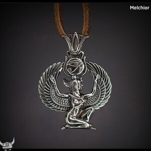 Puede incluir: Collar con colgante de plata que representa una diosa egipcia detallada con alas extendidas, una corona y el Ojo de Horus.