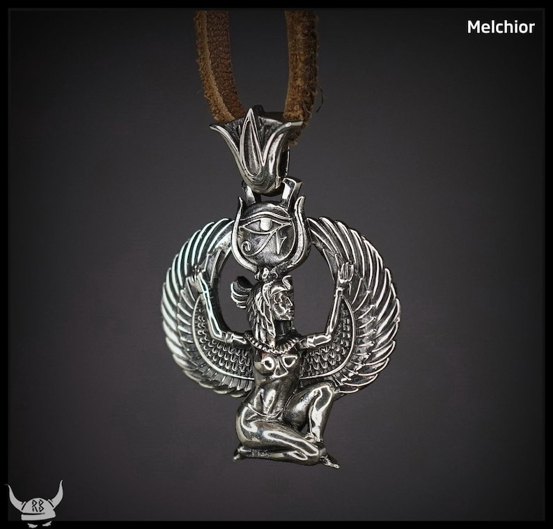 Puede incluir: Collar con colgante de plata que presenta una representaci&oacute;n detallada de la diosa egipcia Isis con las alas extendidas, sosteniendo el s&iacute;mbolo del Ojo de Horus sobre su cabeza. El colgante est&aacute; unido a un cord&oacute;n de cuero marr&oacute;n.