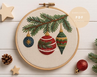 May include: An embroidery hoop containing a fabric panel with a stitched design of a pine branch and three hanging ornaments. The ornaments include a small blue sphere, a large red sphere with white stripes, and a green teardrop shape.