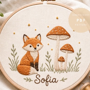 Può includere: Un telaio da ricamo contenente un pannello in tessuto con un disegno ricamato di una volpe, tre funghi e fogliame verde. Il nome Sofia è ricamato in corsivo nella parte inferiore. Un cerchio sovrapposto mostra il testo EMBROIDERY PDF PATTERN.