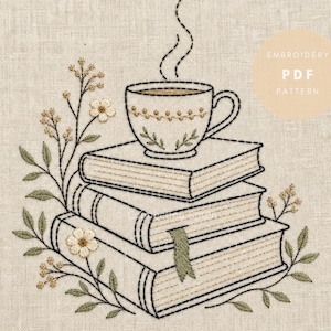 May include: An embroidery pattern on beige fabric featuring a stack of three books topped with a steaming teacup. The design includes delicate floral stems with small white flowers and green leaves, with the text EMBROIDERY PDF PATTERN.