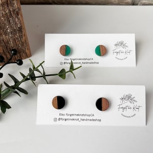 May include: Two pairs of wooden earrings with resin inlays. The first pair has green resin and the second pair has black resin. The earrings are displayed on a white card with the text "Etsy: forgetmeknotshopCA @forgetmeknot_handmadeshop Forget me Knot HANDMADE SHOP".