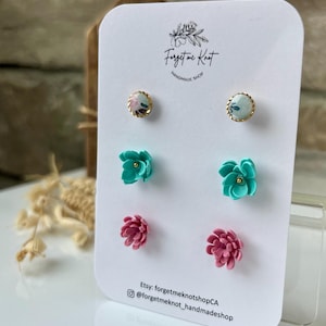 May include: A display card with six pairs of stud earrings. The earrings feature floral designs in pink, teal, and pastel patterns. The card displays the text "Forget me Knot Handmade Shop" and Etsy and Instagram account details.