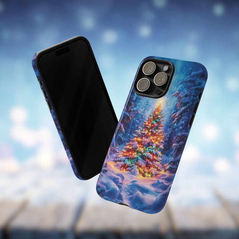 May include: Two phone cases with a winter forest scene. One case is black, the other has a blue background with a Christmas tree covered in colorful lights. Snow covers the ground and the trees.