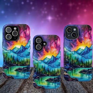 May include: Three phone cases featuring a watercolour design of a mountain lake scene with a sunset. The cases are black with a clear back and feature a colourful design of a lake, mountains, and a sunset sky.