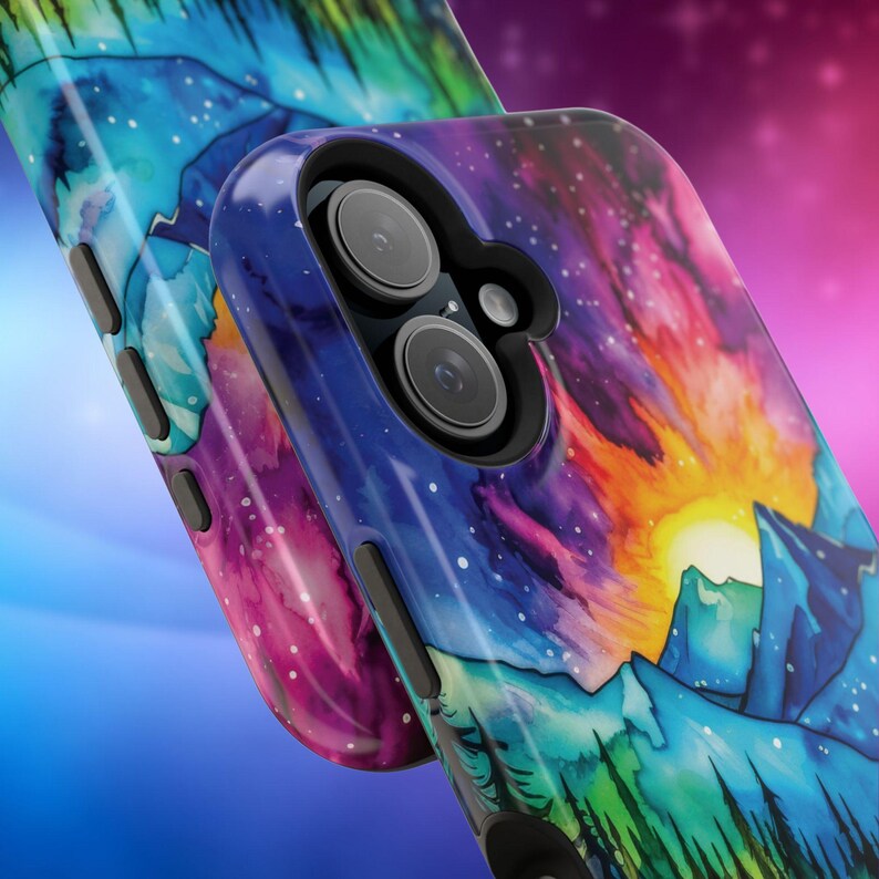 May include: A phone case featuring a watercolour design of a mountain range and a starry sky. The case is blue, purple, green, and orange. The phone case has a cutout for the camera lens.