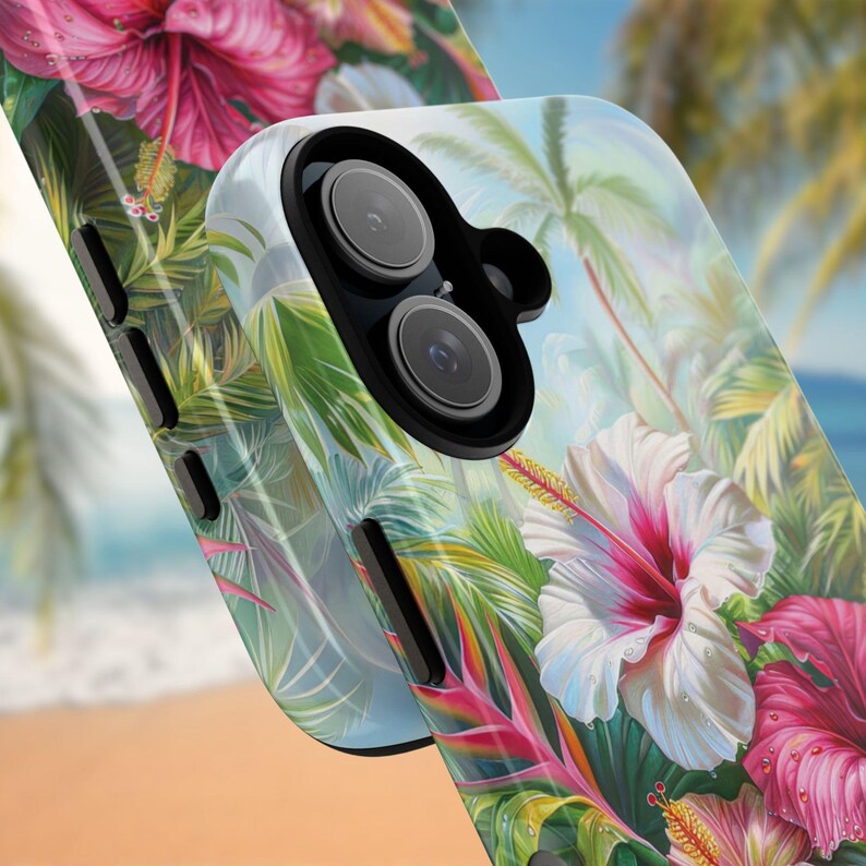May include: A phone case featuring a tropical floral design with hibiscus flowers in shades of pink and white, surrounded by green leaves and palm trees. The case has a glossy finish and a dual-lens camera cutout.