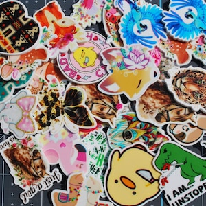 May include: A collection of assorted vinyl stickers featuring diverse designs including a green dinosaur with the text I AM UNSTOPPABLE, a yellow chick with a knife, a butterfly, a leopard, a horse, a flamingo, and various floral animal motifs.