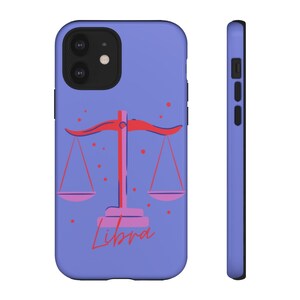 May include: A purple phone case with a pink and red Libra zodiac symbol and the word "Libra" in pink lettering.