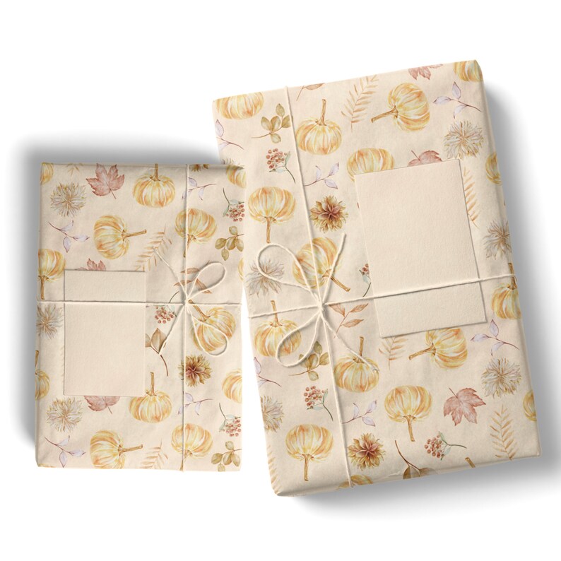 May include: Two gift boxes wrapped in beige paper with a watercolor pattern of small pumpkins, leaves, and berries. The boxes are tied with twine and have blank gift tags.