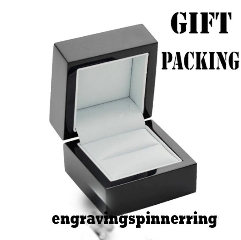 K&ouml;nnte beinhalten: Schwarze Holzkette mit einem wei&szlig;en Samt-Innenfutter. Die Box ist ge&ouml;ffnet und der Deckel ist hochgeklappt. Der Text "GIFT PACKING" ist in Schwarz auf wei&szlig;em Hintergrund gedruckt.