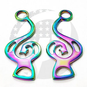 May include: Two iridescent bottle openers in a treble clef shape. The openers have a rainbow finish with hues of blue, green, and purple. The design includes a star-shaped cutout within the curved body of the clef.