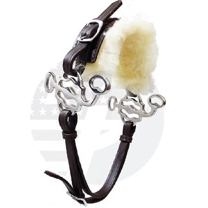 May include: A brown leather horse bit with a fleece noseband and a silver mouthpiece. The bit has a curb chain and a cheek piece with a buckle.
