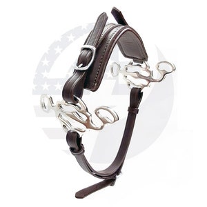 May include: A brown leather horse bit with a silver mouthpiece. The bit has a curved shape and a single ring on each side. The leather is smooth and has a slight sheen.