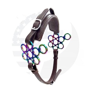 May include: A brown leather horse bit with a rainbow colored metal mouthpiece. The mouthpiece has a unique design with multiple rings.
