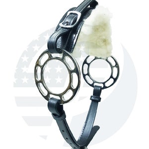 May include: Black leather horse bit with two silver rings. The rings have a cutout design and are padded with white fleece.