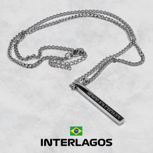 May include: Silver-toned necklace with a rectangular pendant. The pendant has engraved coordinates and hangs from a curb chain. The necklace is displayed on a white surface. The word "INTERLAGOS" is printed below the necklace.