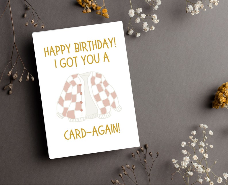 May include: A white card with gold text that reads "Happy Birthday! I got you a card-again!" and a pink and white checkered cardigan illustration.
