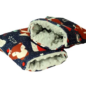 Könnte beinhalten: Ein Paar blaue und weiße Stoff-Armwärmer für Baby-Kinderwagen mit einem Fuchs-Druck. Die Armwärmer sind mit einem weichen, grauen Fleece-Material gefüttert.