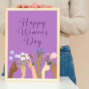 May include: A framed print with a purple background and the text "Happy Women's Day". The print features a variety of hands holding flowers in different colors.