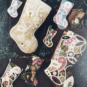 Peut inclure: Une collection de six chaussettes de Noël faites à la main dans différents styles et couleurs. Les chaussettes sont décorées de dentelle, de perles et d'autres embellissements. Certaines des chaussettes sont faites de chutes de tissu, tandis que d'autres sont faites de matériaux plus traditionnels.