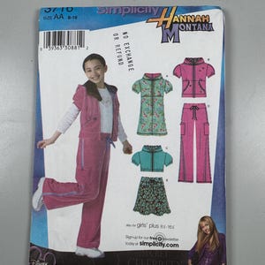 Puede incluir: Un patrón de costura Simplicity para ropa de niña con un esquema de color rosa y turquesa. El patrón incluye una chaqueta, pantalones, falda y top. El patrón es para las tallas 8-16 y tiene licencia de Disney para Hannah Montana.