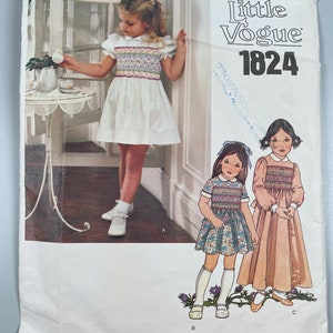 May include: A vintage sewing pattern for children's dresses. The pattern is for a white dress with a colorful embroidered bodice, a floral print dress, and a solid pink dress. The pattern number is 1824 and the brand is Little Vogue.