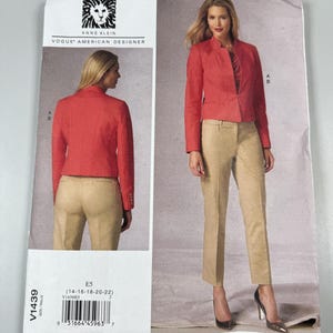 May include: A sewing pattern envelope for an Anne Klein Vogue American Designer jacket and pants set, labeled V1439, featuring a red long-sleeve jacket and tan trousers, with front and back views shown on the packaging for sizes 14 through 22.