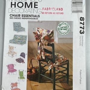May include: A sewing pattern for chair covers. The pattern includes five different designs for chair covers, including a floral design, a gingham design, and a solid colour design. The pattern is from McCall's Home Decorating and is labelled "Chair Essentials".