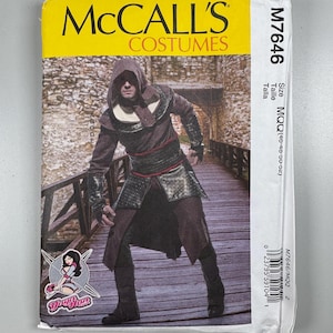 Può includere: Una busta di carta bianca per modelli con un'etichetta gialla che recita "MCCALL'S COSTUMES". La busta presenta una foto di una persona che indossa un costume marrone e nero con cappuccio. Il numero del modello è M7646.