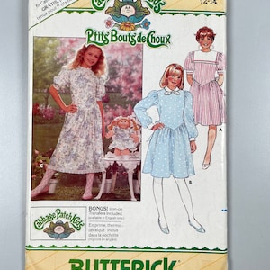 May include: Vintage Butterick sewing pattern for Cabbage Patch Kids outfits, size 12-14. The cover features illustrations of girls in dresses, with the text "P'tits Bouts de Choux" and "Cabbage Patch Kids". Includes iron-on transfers.