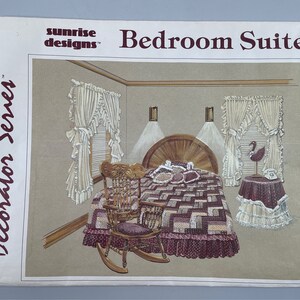 Può includere: Un modello di cucito vintage per una suite da letto, con un letto con una trapunta trapuntata, una sedia a dondolo e un comodino con una lampada. Il modello è di Sunrise Designs e fa parte della serie Decorator.