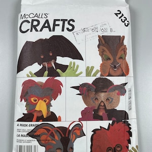 May include: A McCall's Crafts pattern for making six different masks. The masks include a bat, a wolf, a bird, a butterfly, a koala, and a fuzzy creature. The pattern number is 2133.