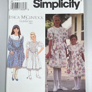 May include: Simplicity sewing pattern number 8253 for girls' dresses. The pattern includes three different styles: a long-sleeved dress with a lace collar, a short-sleeved dress with a lace collar, and a short-sleeved dress with a lace trim. The pattern is for sizes KK (7-12).