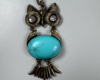 Collana vintage con ciondolo a forma di gufo articolato, in metallo color oro antico, con occhi trasparenti e corpo in gelatina turchese. In buone condizioni. Lunghezza 48 cm (19”), larghezza 6,35 cm (2,5”).