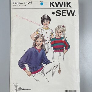 Może przedstawiać: Wzór szycia na bluzki dla dziewczynek, rozmiary 8-10-12-14. Wzór zawiera trzy różne style: bluzę z długim rękawem z kieszenią, koszulkę w paski z krótkim rękawem i koszulkę z krótkim rękawem z nadrukiem kwiatowym. Wzór pochodzi od Kwik Sew Pattern Co., Inc.