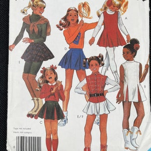 May include: McCall's sewing pattern with illustrations of children's outfits. The pattern includes designs for a cheerleader outfit, a marching band uniform, and other sporty ensembles. The size range is 9-10.