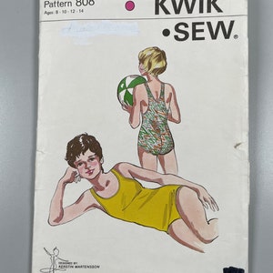 Könnte beinhalten: Ein Schnittmuster für einen Badeanzug für die Größen 8-14. Das Schnittmuster heißt "Kwik Sew" und die Schnittmuster-Nummer ist 808. Das Schnittmuster zeigt zwei Mädchen, die den Badeanzug tragen, eines in einem gelben Badeanzug und das andere in einem grün-orangen Badeanzug.