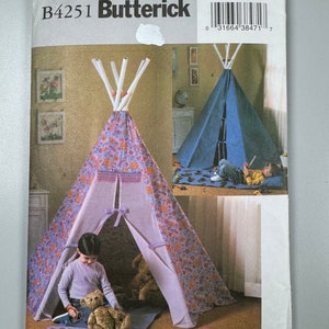 May include: A sewing pattern for a teepee play tent. The pattern is from Butterick and has the number B4251 on it. The pattern shows a child playing inside the teepee with a teddy bear.