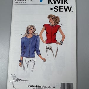 以下が含まれることがあります： Kwik Sewの縫製パターン、パターン1602。2つの女性用トップのイラストが特徴です。1つは赤いキャップスリーブのトップス、もう1つは青いカーディガンです。パターンサイズはXSからLです。Kwik Sewのロゴが上部にあります。