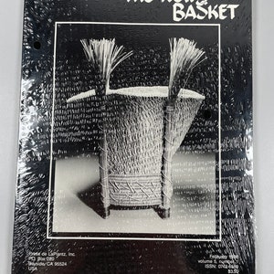 May include: The News Basket magazine cover featuring a black and white photograph of a woven basket with a black background. The magazine title is in white text. The text on the cover reads "The News Basket, February 1988, volume 5, number 1, ISSN: 0742-6569, £3.50."
