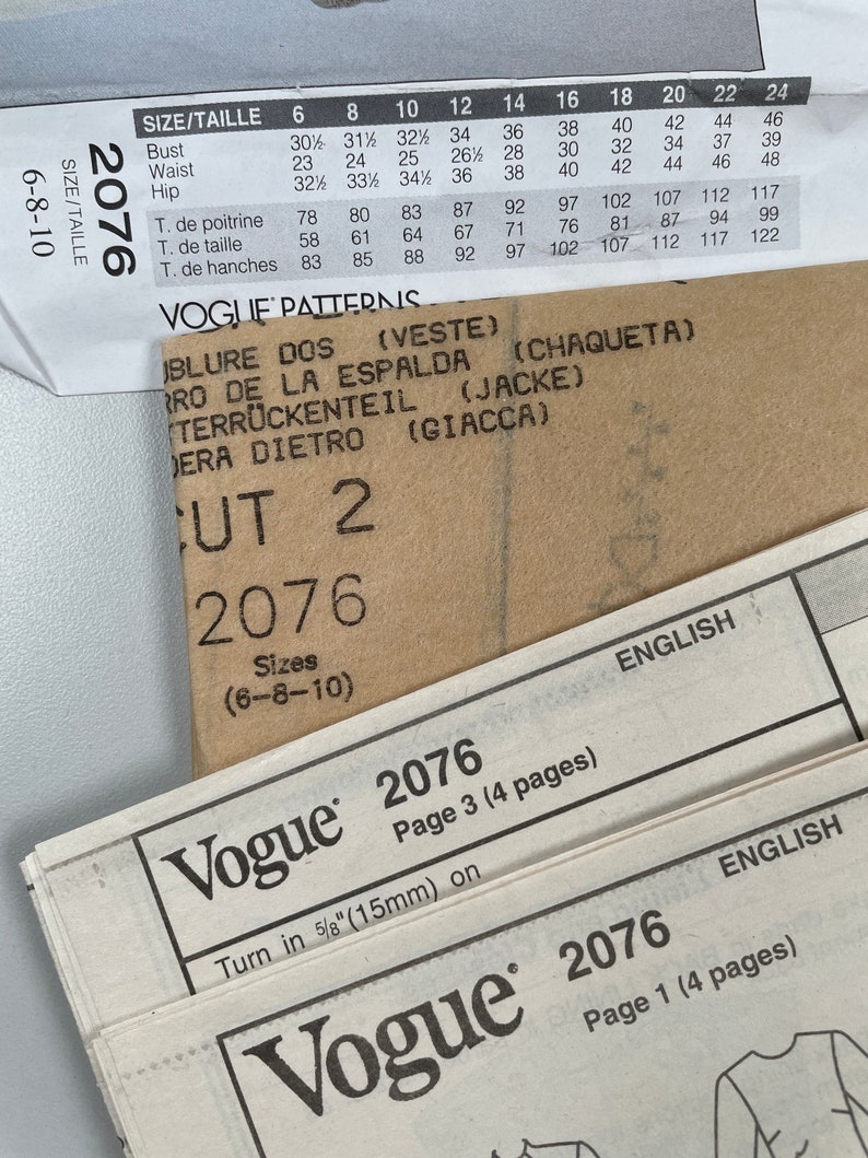 May include: A close-up of a Vogue sewing pattern for sizes 6-8-10. The pattern is for a jacket and includes instructions for cutting and sewing. The pattern number is 2076.